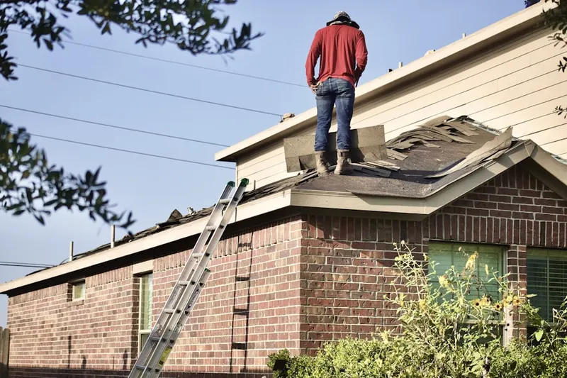 Professional roofer working on a residential roof in Garden City Park